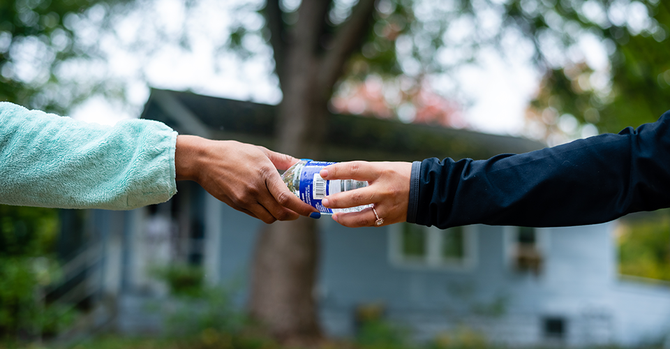 Giving a water bottle to another person